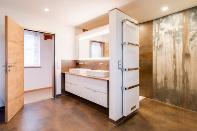 Photo of a large asian 3/4 bathroom in Other with flat-panel cabinets, white cabinets, brown tile, white walls, a vessel sink, wood benchtops, brown floor and beige benchtops.