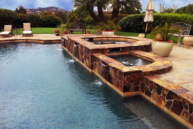 This is an example of a large contemporary backyard custom-shaped pool in San Diego with a hot tub and concrete pavers.