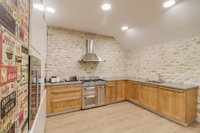 Large modern l-shaped eat-in kitchen in Other with an undermount sink, light wood cabinets, limestone splashback, stainless steel appliances, light hardwood floors, no island, brown floor and grey benchtop.