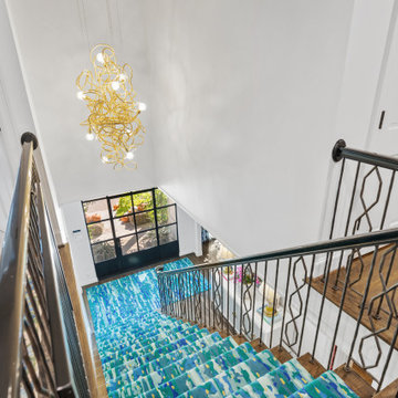 Vibrant Staircase with Bold Blue Runner and Artistic Décor