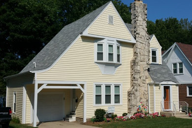 Example of a mid-sized ornate yellow two-story vinyl gable roof design in Chicago