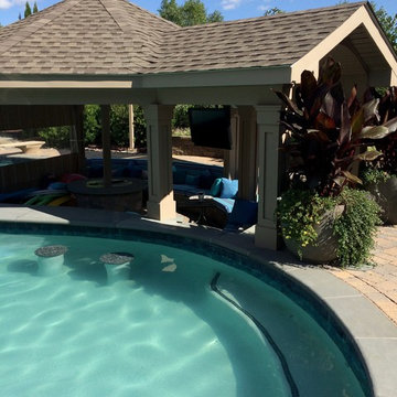 Outdoor living space with pool and sunken bar, as well as pool house