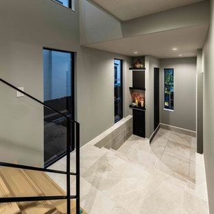 他の地域の中サイズの両開きドアモダンスタイルのおしゃれな玄関 (グレーの壁、セラミックタイルの床、黒いドア、グレーの床) の写真