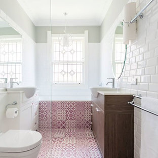 Immagine di una piccola stanza da bagno per bambini minimalista con ante in stile shaker, ante in legno scuro, vasca da incasso, WC sospeso, piastrelle in ceramica, pareti bianche, pavimento con piastrelle in ceramica, top in quarzo composito, doccia ad angolo, piastrelle bianche, lavabo integrato, pavimento rosa e porta doccia a battente