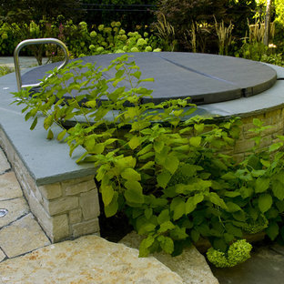 Inredning av en klassisk rund ovanmarkspool på baksidan av huset, med spabad och naturstensplattor