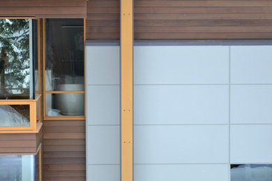 Photo of a large contemporary three-storey brown exterior in Vancouver with wood siding and a shed roof.
