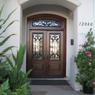 Idee per una porta d'ingresso tradizionale di medie dimensioni con pareti bianche, pavimento in travertino, una porta a due ante, una porta in legno scuro e pavimento beige