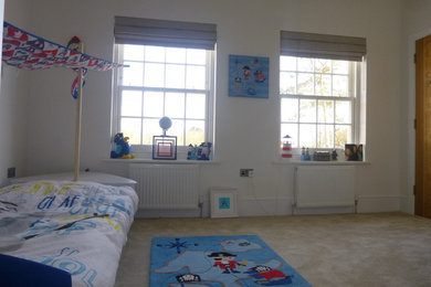 Design ideas for a medium sized contemporary guest bedroom in London with white walls and carpet.