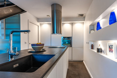 Diseño de cocina minimalista con fregadero bajoencimera, puertas de armario blancas y encimera de cuarcita