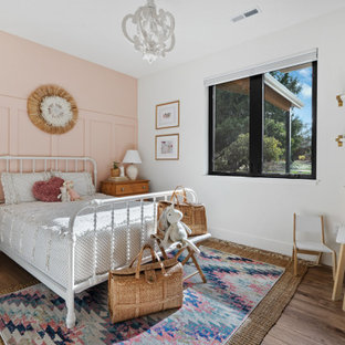 Foto di una cameretta per bambini country di medie dimensioni con pareti rosa, pavimento in laminato, pavimento bianco e pareti in legno