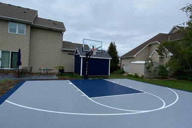 This is an example of a traditional back garden in Minneapolis with an outdoor sport court.