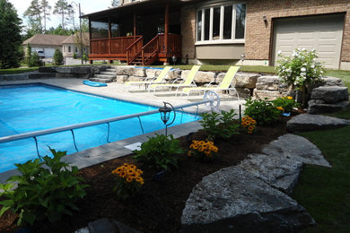 Mid-sized elegant backyard stone patio photo in Toronto