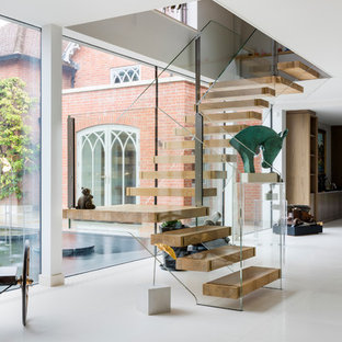 Contemporary wood l-shaped glass railing staircase in Wiltshire with open risers.