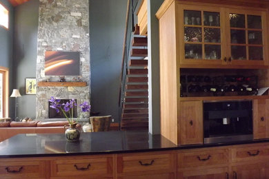 Large elegant u-shaped dark wood floor kitchen pantry photo in Seattle with a farmhouse sink, raised-panel cabinets, medium tone wood cabinets, quartzite countertops, black backsplash, stainless steel appliances and an island