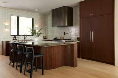 Inspiration for a large transitional l-shaped eat-in kitchen in Toronto with an undermount sink, flat-panel cabinets, medium wood cabinets, glass benchtops, white splashback, porcelain splashback, panelled appliances, light hardwood floors, with island, beige floor and multi-coloured benchtop.