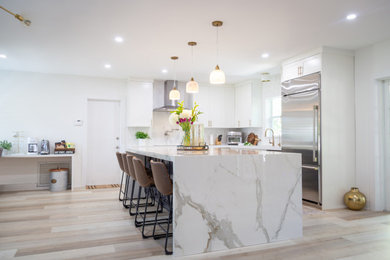 Inspiration for a large transitional vinyl floor and beige floor eat-in kitchen remodel in Miami with a single-bowl sink, shaker cabinets, white cabinets, quartz countertops, white backsplash, stone tile backsplash, stainless steel appliances, an island and white countertops