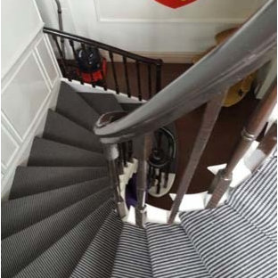 Photo of a medium sized and mixed contemporary carpeted spiral staircase in London with carpeted risers.