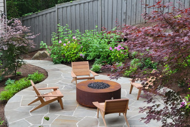 Photo of a mid-sized partial sun backyard stone landscaping in Portland with a fire pit for summer.