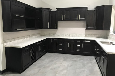 Open concept kitchen - mid-sized transitional u-shaped slate floor and gray floor open concept kitchen idea in Los Angeles with an undermount sink, shaker cabinets, black cabinets, quartzite countertops, gray backsplash, stone slab backsplash, stainless steel appliances and no island