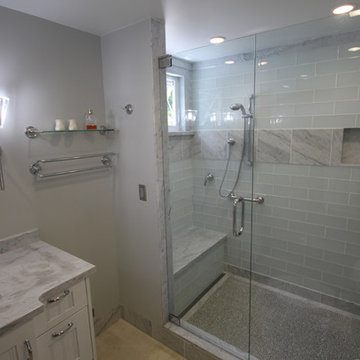Glass and Carrara Marble shower with linear drain and recycle glass pebble floor