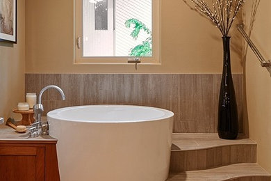 Japanese bathtub - large asian master gray tile and porcelain tile cork floor japanese bathtub idea in Portland with recessed-panel cabinets, medium tone wood cabinets, brown walls and quartz countertops