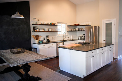 Mid-sized minimalist l-shaped dark wood floor, brown floor and vaulted ceiling eat-in kitchen photo in Austin with an undermount sink, shaker cabinets, white cabinets, granite countertops, white backsplash, subway tile backsplash, stainless steel appliances and an island