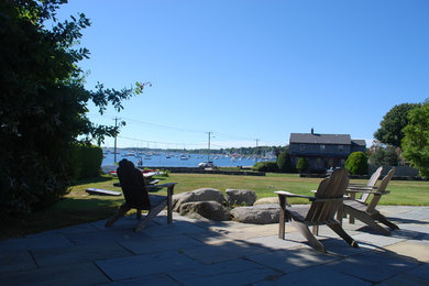 This is an example of a mid-sized traditional full sun backyard stone landscaping in Providence for summer.