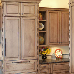Imagen de cocina en U, mediterránea, grande, abierta, con armarios con paneles con relieve, puertas de armario con efecto envejecido, salpicadero gris, salpicadero de azulejos de piedra, electrodomésticos con paneles, suelo de pizarra y una isla