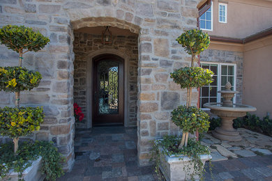 Front door - huge mediterranean front door idea in Los Angeles with a dark wood front door