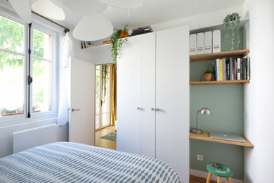 Idées déco pour une petite chambre scandinave avec un mur vert et parquet clair.