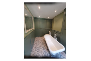 Inspiration for a medium sized contemporary family bathroom in West Midlands with green cabinets, a freestanding bath, ceramic flooring, wooden worktops, multi-coloured floors and a freestanding vanity unit.