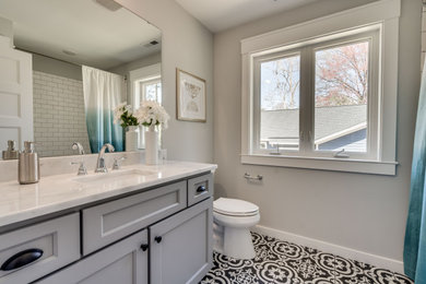 Inspiration for a mid-sized farmhouse master black and white tile and subway tile porcelain tile and black floor bathroom remodel in Raleigh with shaker cabinets, gray cabinets, a two-piece toilet, gray walls, an undermount sink, solid surface countertops and white countertops