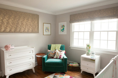 Minimalist girl dark wood floor and brown floor nursery photo in New York with beige walls
