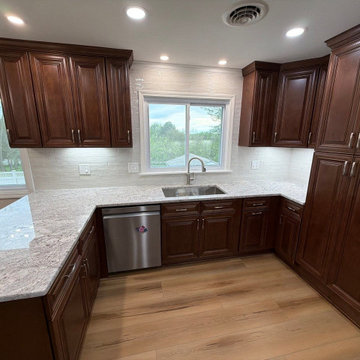 USCD cabinetry accompanied granite countertops, porcelain tile backsplash and Ca