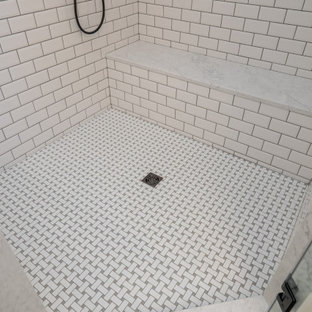 Inspiration for a mid-sized transitional master white tile and subway tile ceramic floor and gray floor bathroom remodel in Other with recessed-panel cabinets, white cabinets, a one-piece toilet, gray walls, an undermount sink, quartz countertops, a hinged shower door and white countertops