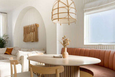 Réalisation d'une petite salle à manger design avec une banquette d'angle, un mur blanc et parquet clair.