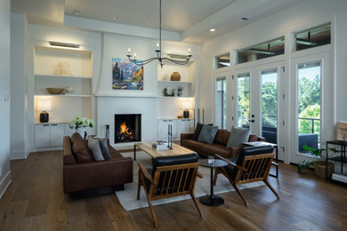 Mid-sized elegant enclosed medium tone wood floor, brown floor and tray ceiling living room photo in Other with white walls, a standard fireplace and a plaster fireplace