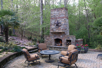 Expansive eclectic backyard patio in Charlotte with a fire feature, concrete pavers and no cover.