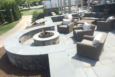 Patio - large traditional backyard stone patio idea in New York with a fire pit and no cover