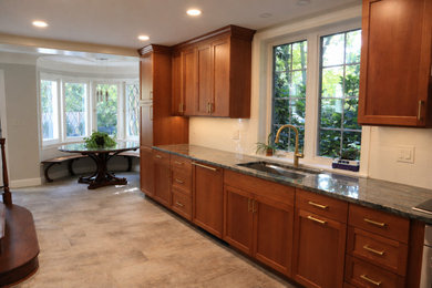 Large trendy u-shaped porcelain tile and beige floor eat-in kitchen photo in DC Metro with an undermount sink, flat-panel cabinets, marble countertops, yellow backsplash, subway tile backsplash, stainless steel appliances and multicolored countertops