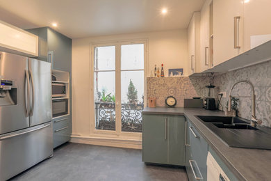 Cette image montre une grande cuisine parallèle et haussmannienne design fermée avec une crédence en carreau de ciment, un électroménager en acier inoxydable et un sol en vinyl.