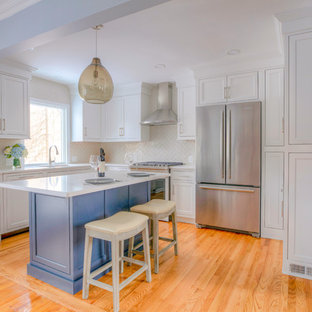 Design ideas for a small transitional l-shaped kitchen pantry in New York with an undermount sink, shaker cabinets, white cabinets, quartzite benchtops, grey splashback, subway tile splashback, stainless steel appliances, medium hardwood floors, with island and white benchtop.