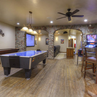 Design ideas for an expansive mediterranean walk-out basement in Denver with beige walls and medium hardwood flooring.