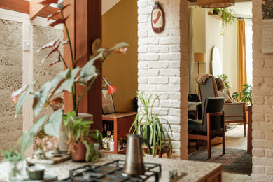 Photo of a medium sized contemporary single-wall open plan kitchen in London with flat-panel cabinets, medium wood cabinets, composite countertops, medium hardwood flooring and an island.