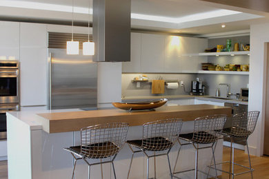 Design ideas for a mid-sized modern l-shaped eat-in kitchen in Miami with an undermount sink, flat-panel cabinets, white cabinets, quartz benchtops, grey splashback, stone slab splashback, stainless steel appliances, medium hardwood floors and with island.