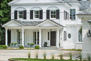 Example of a mid-sized transitional white two-story brick house exterior design in New York with a hip roof and a tile roof