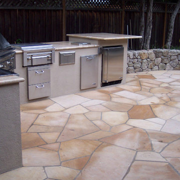 Flagstone patio with a stacked stone wall in the back and an accompanying outdoo