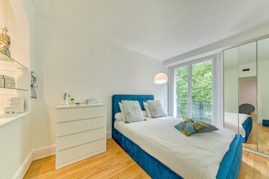 Réalisation d'une chambre blanche et bois minimaliste avec un mur blanc et un sol en bois brun.