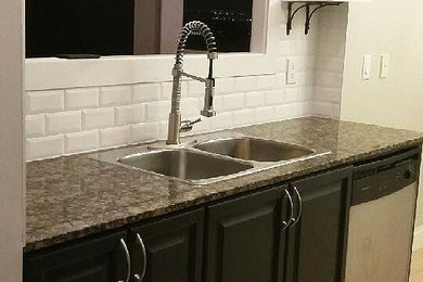 Inspiration for a mid-sized transitional galley porcelain tile and beige floor open concept kitchen remodel in Toronto with a drop-in sink, raised-panel cabinets, dark wood cabinets, granite countertops, white backsplash, ceramic backsplash, stainless steel appliances and no island