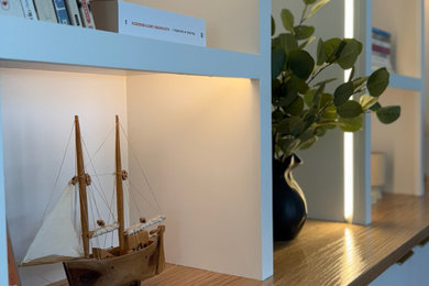 Inspiration for a mid-sized modern loft-style medium tone wood floor family room library remodel in Boston with white walls and no tv